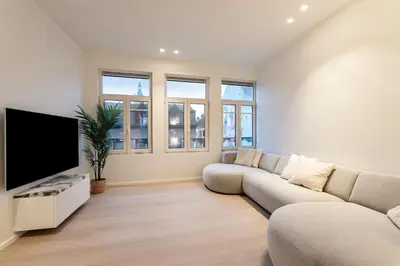 a living room with a couch and a flat screen tv at Luxury escape in the heart of historic Mechelen in Mechelen