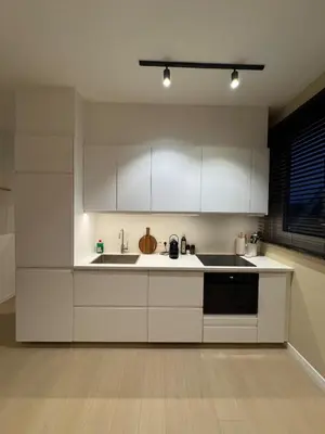a kitchen with white cabinets and a sink at Cosy and Fully Equipped Studio in Antwerp