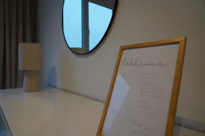 a sign on a shelf in a room with a mirror at Cosy and Fully Equipped Studio in Antwerp