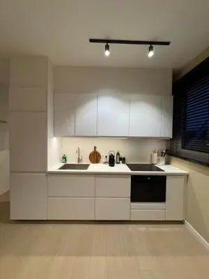 a kitchen with white cabinets and a sink at Cosy and Fully Equipped Studio in Antwerp