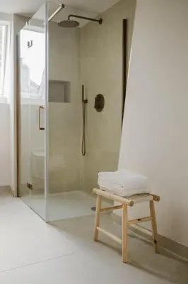 a bathroom with a shower with a bench and a glass shower stall at Apartment in the House of the Harbor Captain in Antwerp