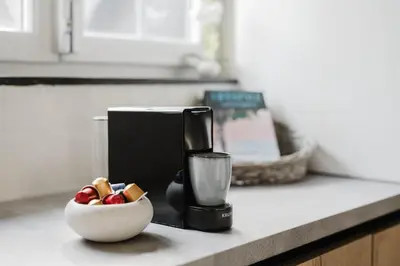 a coffee maker and a bowl of fruit on a kitchen counter at Apartment in the House of the Harbor Captain in Antwerp
