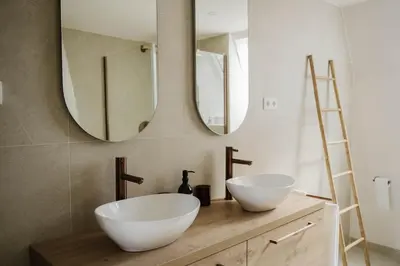 a bathroom with two white sinks and two mirrors at Apartment in the House of the Harbor Captain in Antwerp