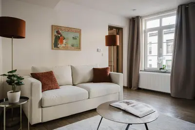 a living room with a white couch and a table at Apartment in the House of the Harbor Captain in Antwerp