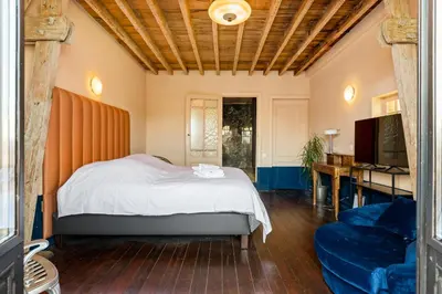 a bedroom with a bed and a tv and a couch at Boutique Baron Osy Suite Second Street in Antwerp