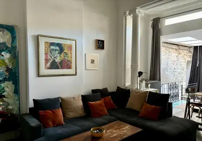 a living room with a black couch with colorful pillows at Art Apartment in Brussels