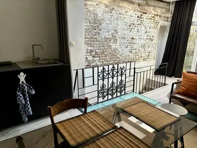 a living room with a glass table and a brick wall at Art Apartment in Brussels