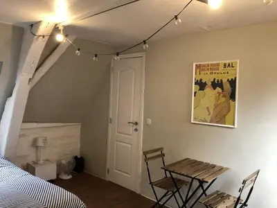 a room with a table and chairs and a bed at Bruxelles centre petite chambre privée au Sablon ! in Brussels