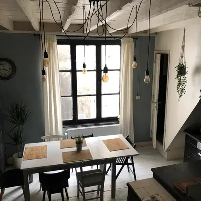 a dining room with a table and a large window at Bruxelles centre petite chambre privée au Sablon ! in Brussels
