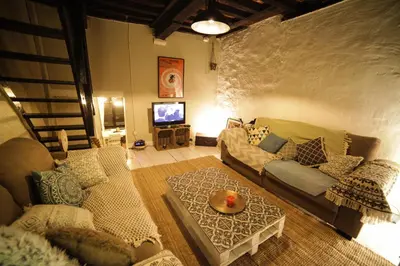 a living room with a couch and a tv at Bruxelles centre petite chambre privée au Sablon ! in Brussels