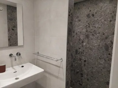 a white bathroom with a sink and a shower at Krie1 by Luttelkolen in Tielt