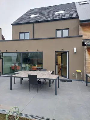 a patio with a table and chairs in front of a house at Krie1 by Luttelkolen in Tielt