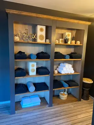 a shelf with towels and other items in a room at Escape to Unwind in Putte