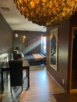 a room with a bed and a table with a laptop at Escape to Unwind in Putte