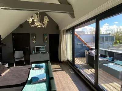 a living room with a view of a balcony at Escape to Unwind in Putte
