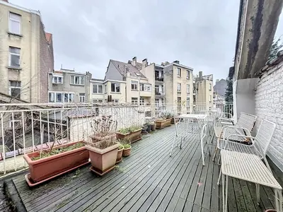 an outdoor deck with potted plants and a table and chairs at Bruxelles Midi in Brussels