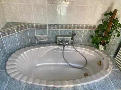 a large white tub in a tiled bathroom at Wahwo Baki in Wachtebeke