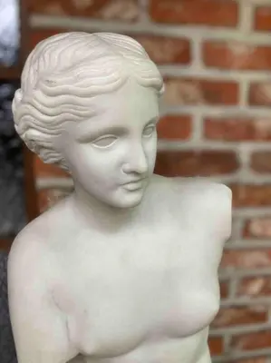a statue of a young boy in front of a brick wall at Wahwo Baki in Wachtebeke