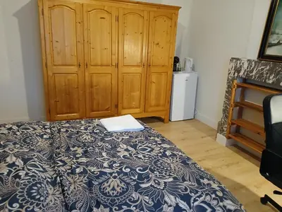 a bedroom with a bed and a wooden cabinet at Bloemetje in Asse
