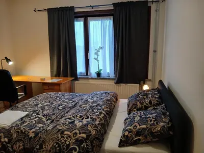 a bedroom with a bed and a desk and a window at Bloemetje in Asse