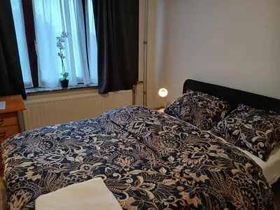 a bed with a blanket and pillows in a bedroom at Bloemetje in Asse
