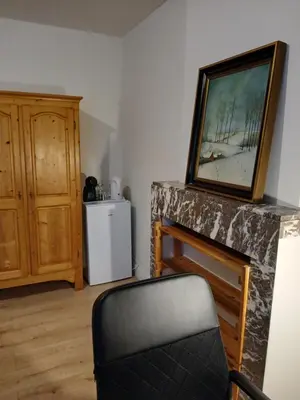 a room with a fireplace with a picture on the wall at Bloemetje in Asse
