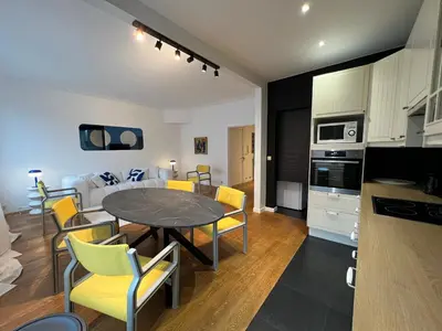 a kitchen and a living room with a table and chairs at Plein centre de Waterloo! 1 in Waterloo