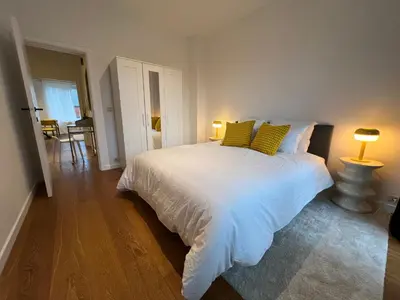 a bedroom with a white bed with yellow pillows at Plein centre de Waterloo! 1 in Waterloo