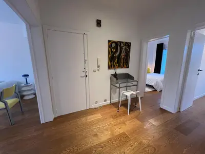 a white room with a bedroom and a table and a bed at Plein centre de Waterloo! 1 in Waterloo