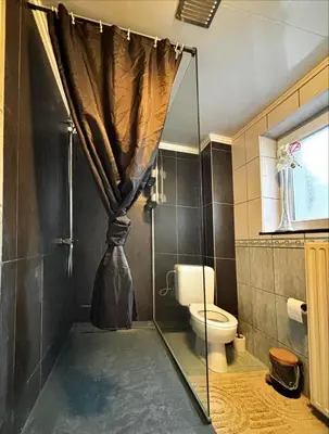 a bathroom with a shower with a toilet and a curtain at Room in Guest room - Charming Guest Room in Historic Brussels Mansion in Brussels