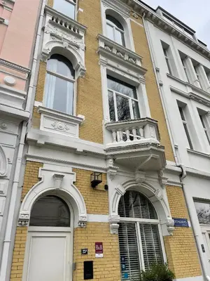 a brick building with two windows and a balcony at Museum Suites in Antwerp