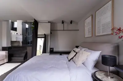 a bedroom with a large white bed and a staircase at Museum Suites in Antwerp