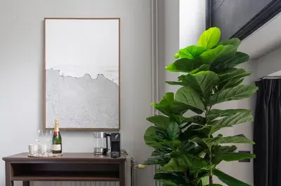 a plant in a room with a table and a picture at Museum Suites in Antwerp