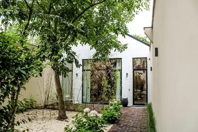 a white house with a garden and a walkway at Oscarsleeps in Ghent