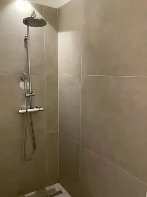 a shower with a shower head in a bathroom at Oscarsleeps in Ghent
