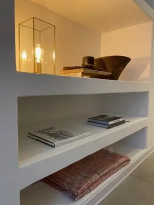 a shelf with books and a mirror in a room at Oscarsleeps in Ghent