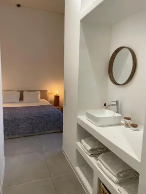 a white bathroom with a sink and a bed at Oscarsleeps in Ghent