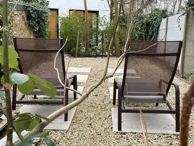 two chairs sitting next to each other in a garden at Oscarsleeps in Ghent