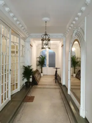 a hallway with white walls and a chandelier at Maison d'hôtes de Xavier in Brussels