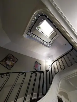 a ceiling with a skylight and a staircase with a window at Maison d'hôtes de Xavier in Brussels