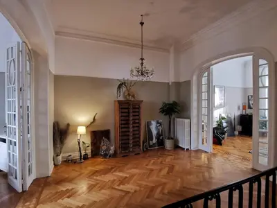 a living room with a wooden floor and a chandelier at Maison d'hôtes de Xavier in Brussels