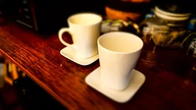 two white cups and saucers on a wooden table at Maison d'hôtes de Xavier in Brussels