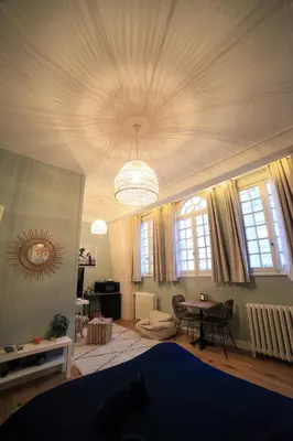 a living room with a ceiling with a chandelier at Maison d'hôtes de Xavier in Brussels