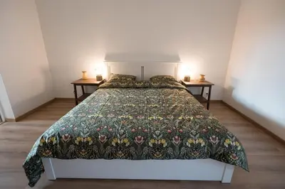 a bedroom with a bed with a floral bedspread at Cozy apartement in the heart of Brussels in Brussels