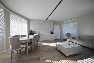 a kitchen and living room with a table and chairs at Luxe accomodatie d'einde in Beerse