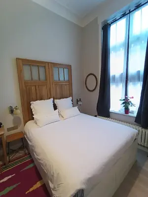 a large white bed in a room with a window at Marilou and Dalibor's room in Brussels