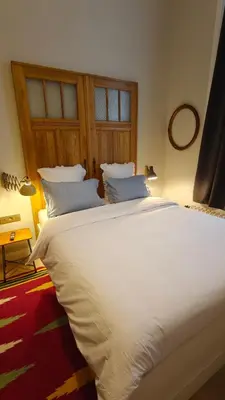 a large white bed in a room with a mirror at Marilou and Dalibor's room in Brussels