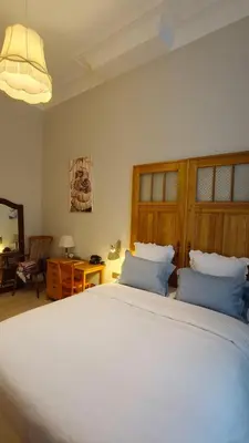 a bedroom with a large white bed with blue pillows at Marilou and Dalibor's room in Brussels