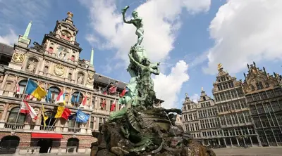 a statue in front of a building with flags at Charming 18th Century Gem in the Heart of Old Town in Antwerp