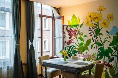 a dining room with a table and a flower mural on the wall at Charming 18th Century Gem in the Heart of Old Town in Antwerp